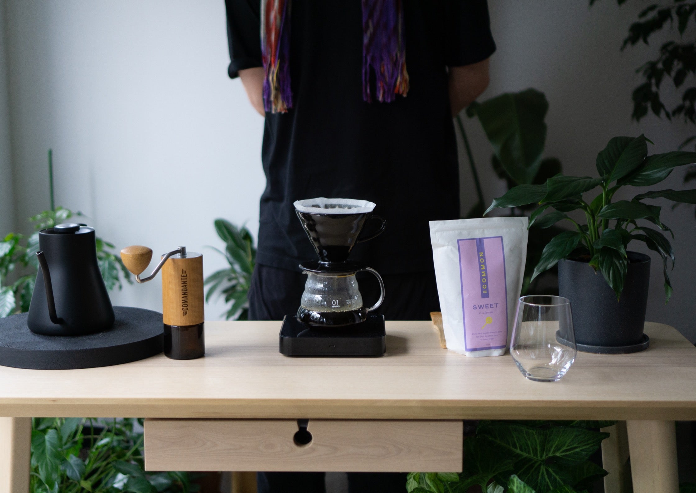 Vaughan's demo setup for Charlie: coffee, kettle, grinder, pour-over, scales, spoon, and a glass tumbler