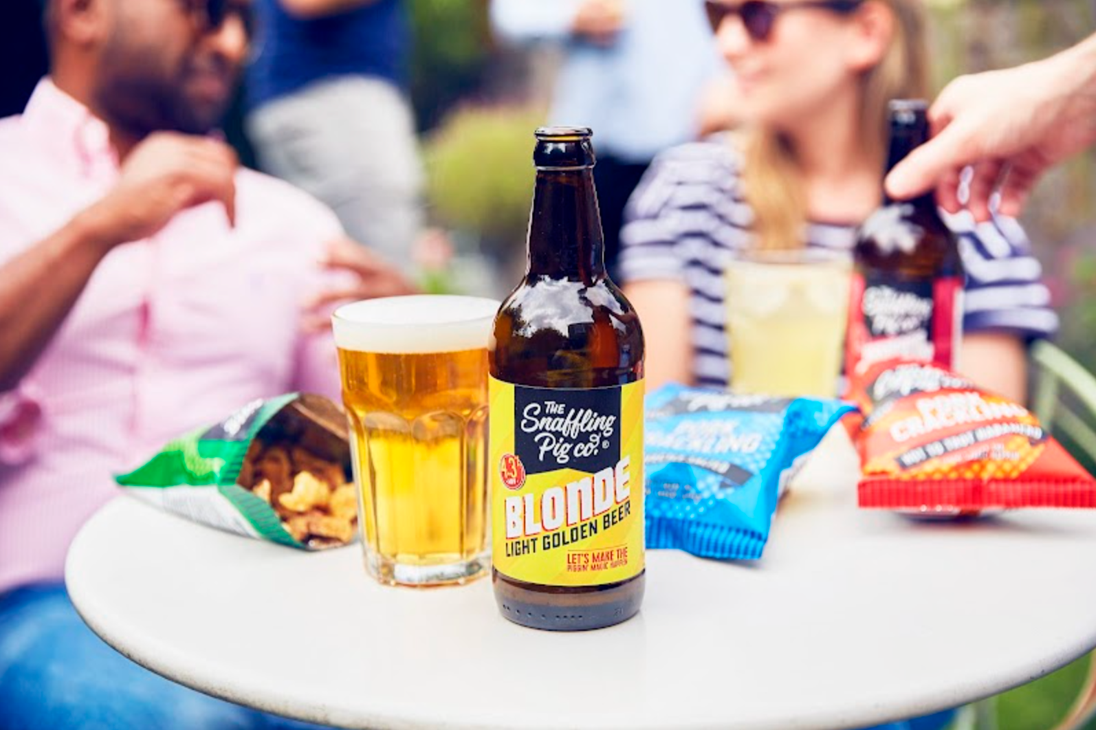 Snaffling Pig beer on a table with people in the background