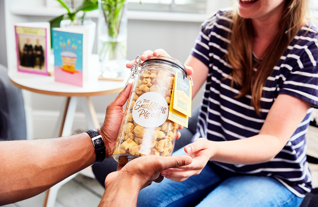 A person handing a gift jar to a friend