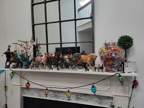 Display of Copperfox and Breyer models along a mantle.  Metal horse that fell is near the left end.