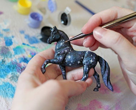 https://cdn.shopify.com/s/files/1/0714/1551/files/person_painting_a_breyer_stablemate_480x480.jpg?v=1637010348