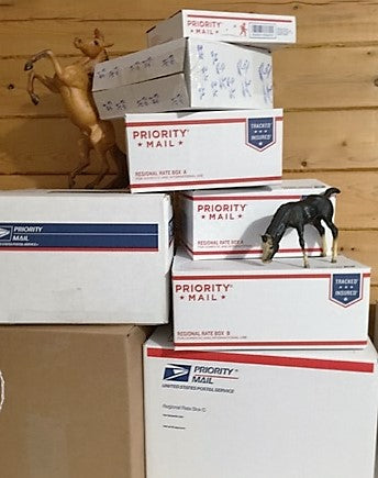 A few model horses playing on shipping boxes