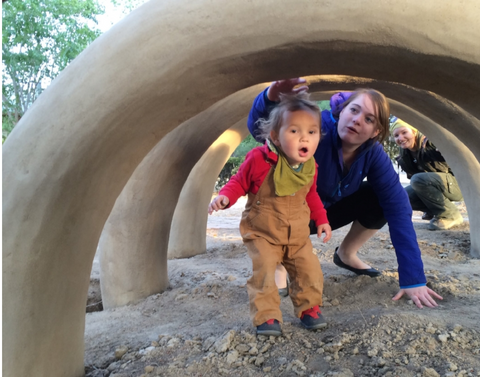 image of a child walking under an earthen arch