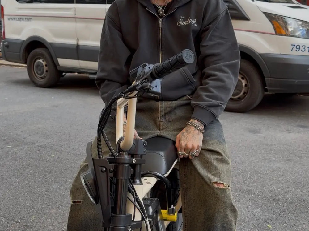 Person sitting on a Macfox X7 eBike in an urban parking area