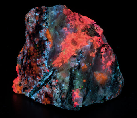 A fluorescent mineral specimen of tugtupite, sodalite, analcime from Greenland