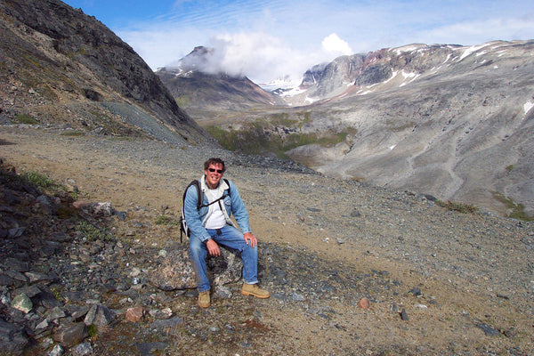 a man in front of kvanefeld and illimaussaq