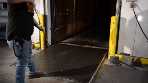 Homme montrant comment fonctionne un niveleur de quai mécanique