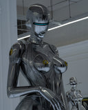 Naked robot woman with boobs standing in the modern room looking at something