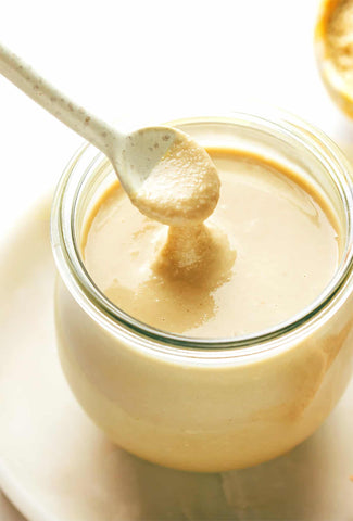 A jar of chilled tahini, resting comfortably in the refrigerator, ready to enhance your culinary creations with its creamy texture and rich flavor.