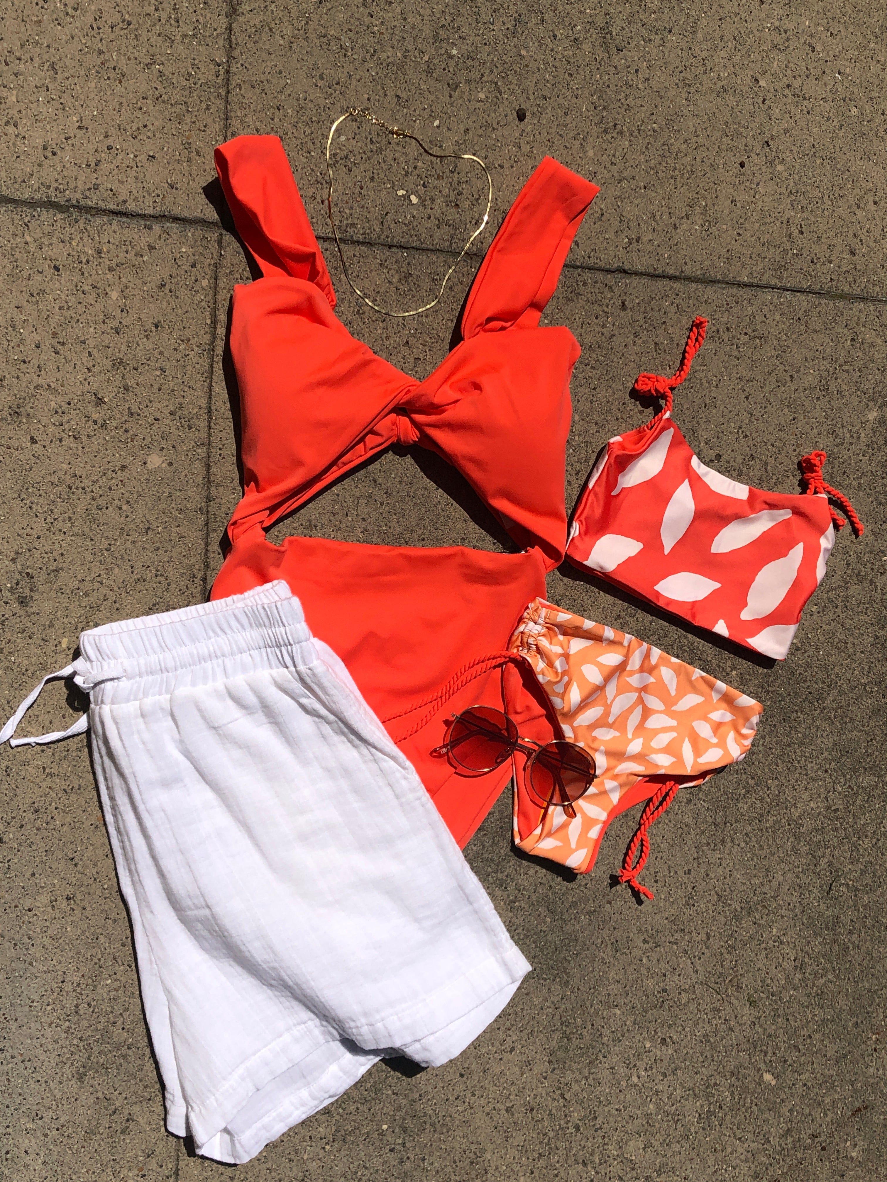 orange one piece swimsuit and matching kids two piece swimsuit with white shorts and accessories