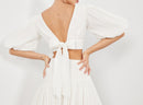 white puff sleeve crop top with large bow tie in back of top 