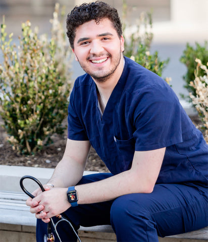 Smiling young nurse sitting on bench holding stethoscope