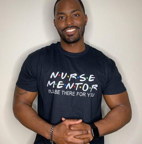 Smiling nurse poses wearing "Nurse Mentor" shirt