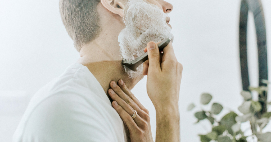 man shaving with foam in the mirror
