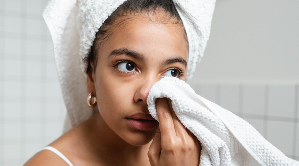 Woman cleansing face with a towel