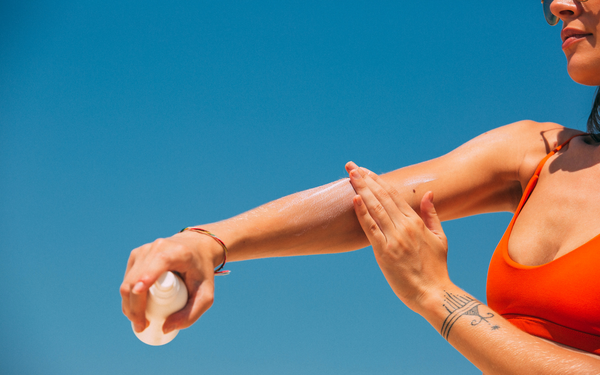 woman applying sunscreen to her arms