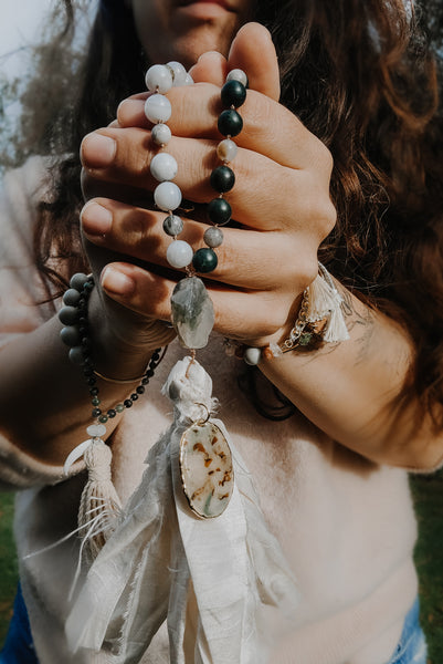 Close up of hands grasping a handknotted Mala