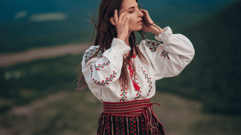 Roma woman on a hillside taking a deep breath as she pulls back her hair