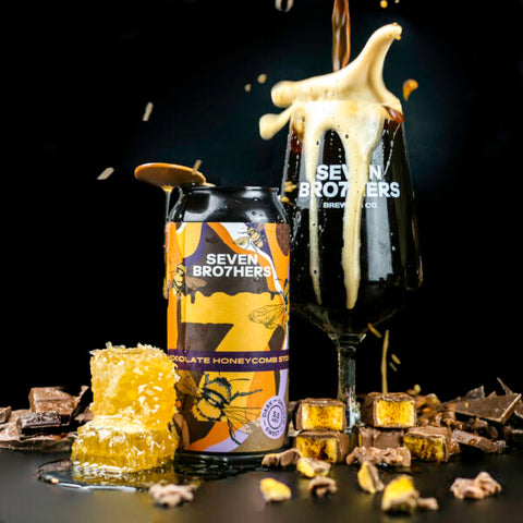 A can of Chocolate Honeycomb Stout, with a glass poured next to it and chocolate/honey surrounding.