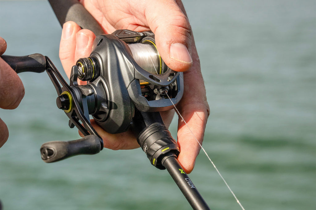 Angler holding fishing rod with fish finder screen in foreground.