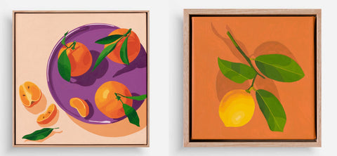 two framed original paintings of fruit hanging together on a white wall