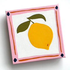 canvas oil painting of a bright yellow lemon with olive green leaves and a pink and orange border