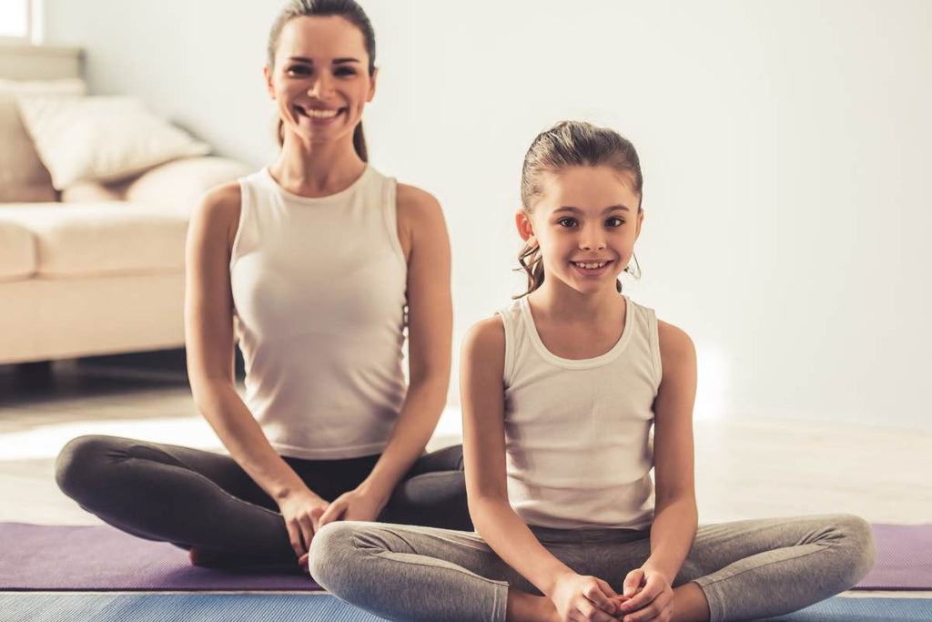Mother and daughter at yoga, stretch classes, ballet class, smiling, yoga pose