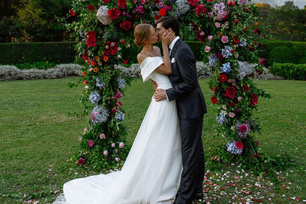 Wedding kiss with bride and groom, wedding flowers , wedding arch