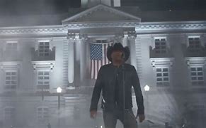 Jason Aldean standing in front of a courthouse.