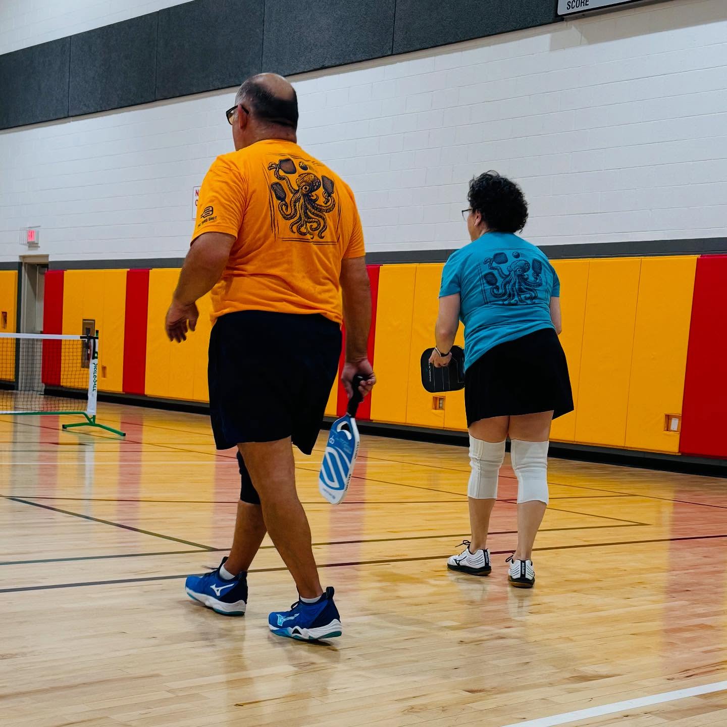 Couple wearing Kraken pickleball shirts – bold octopus design for players with reach and power
