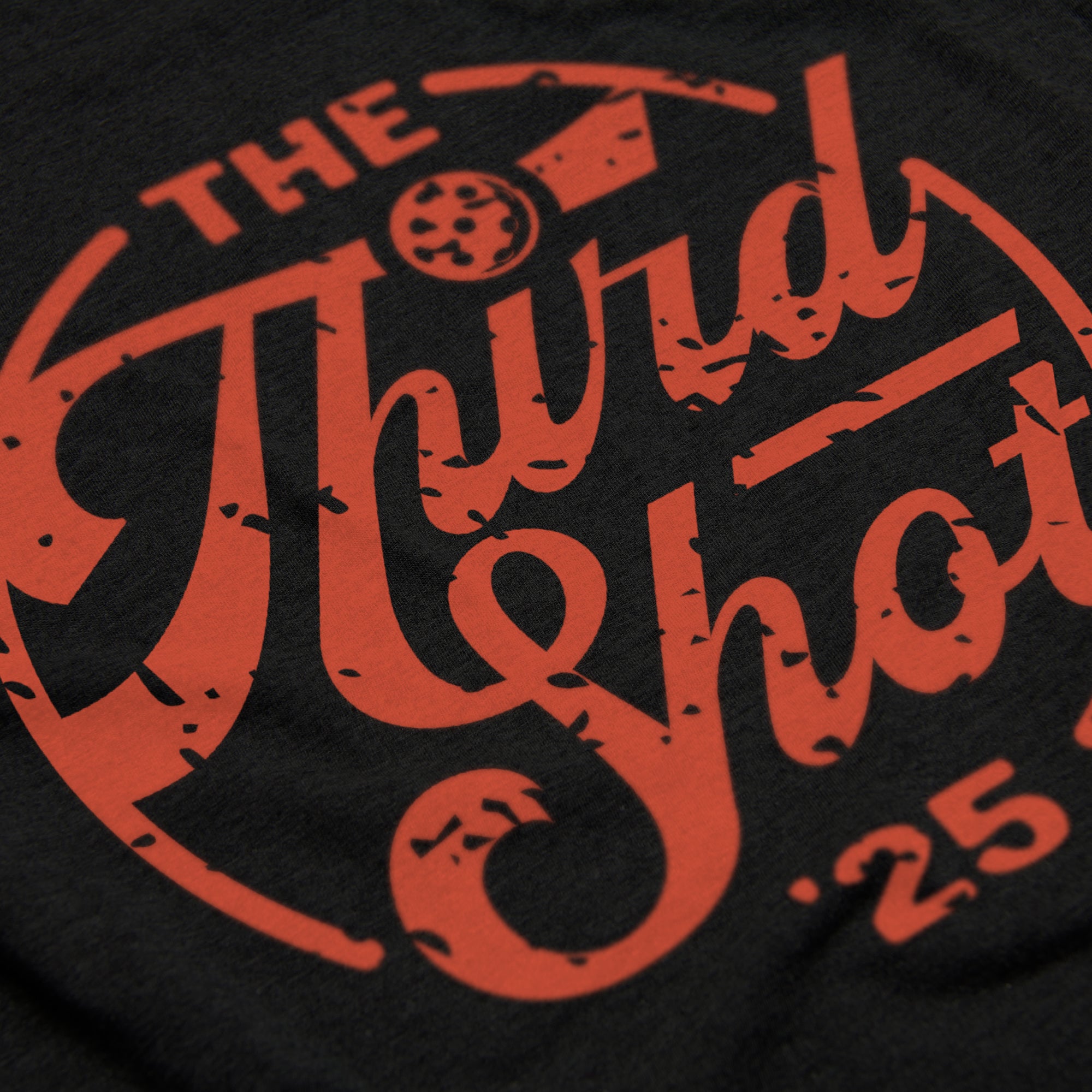 Close-up of Men’s Heritage pickleball shirt in black – retro circular logo detail
