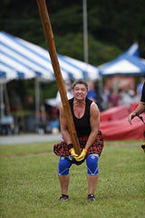 A women participating in a caber toss competition Photo: Mike Lacey 