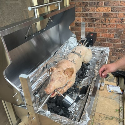 1200 mm Hooded Spartan BBQ Spit showing the uncooked pig ready to go with charcoal lit in the pan