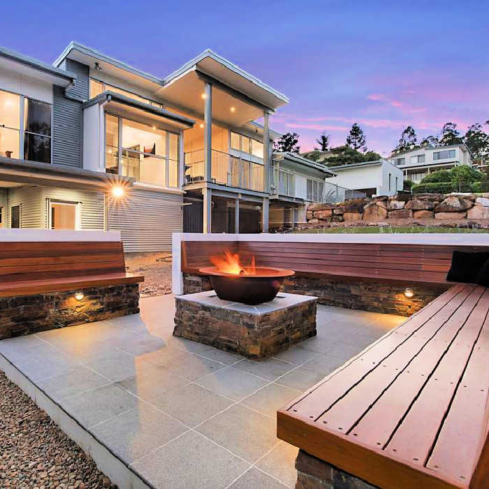 stylish modern era home with styled backyard and fire pit centre piece