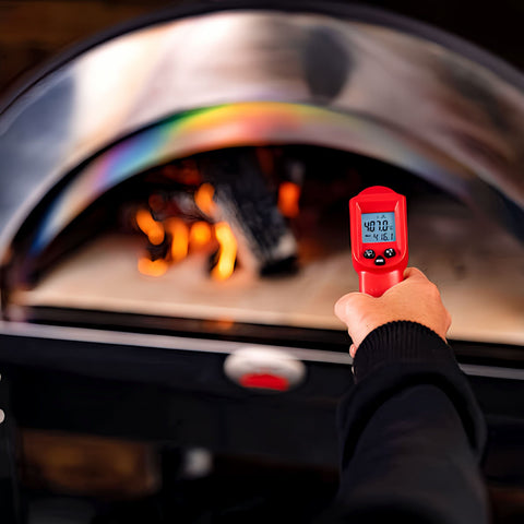 Infrared thermometer pointed at the fire inside pizza oven