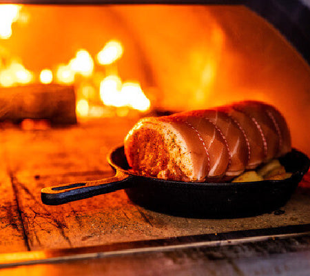 roast pork cooking in woof fire pizza oven