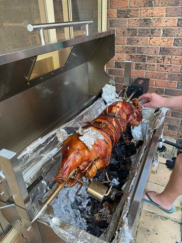 pig on a spit using a charcoal bbq hooded spartan series