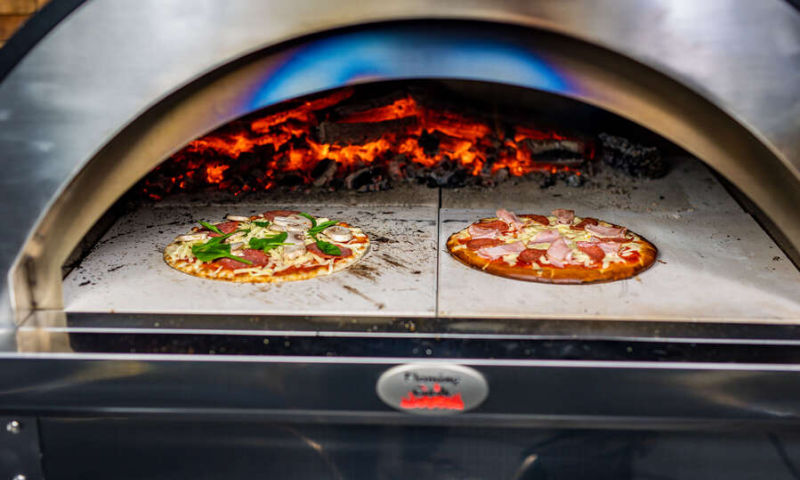premium pizza oven showing two pizzas cooking