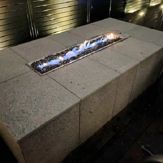 Galio Gas Linear Fireplace Insert | Automatic | Manual inserted inside a granite outdoor setting