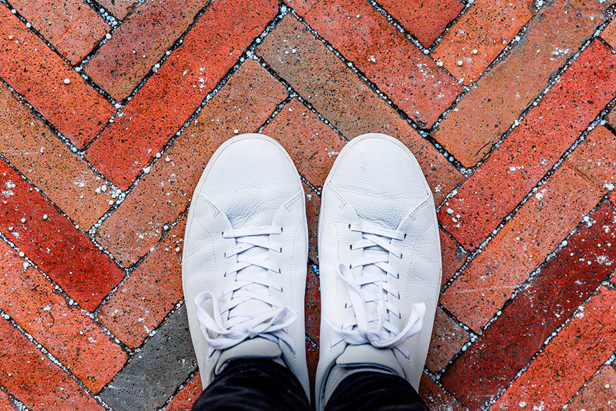 Looking down on a pair of wide white shoes