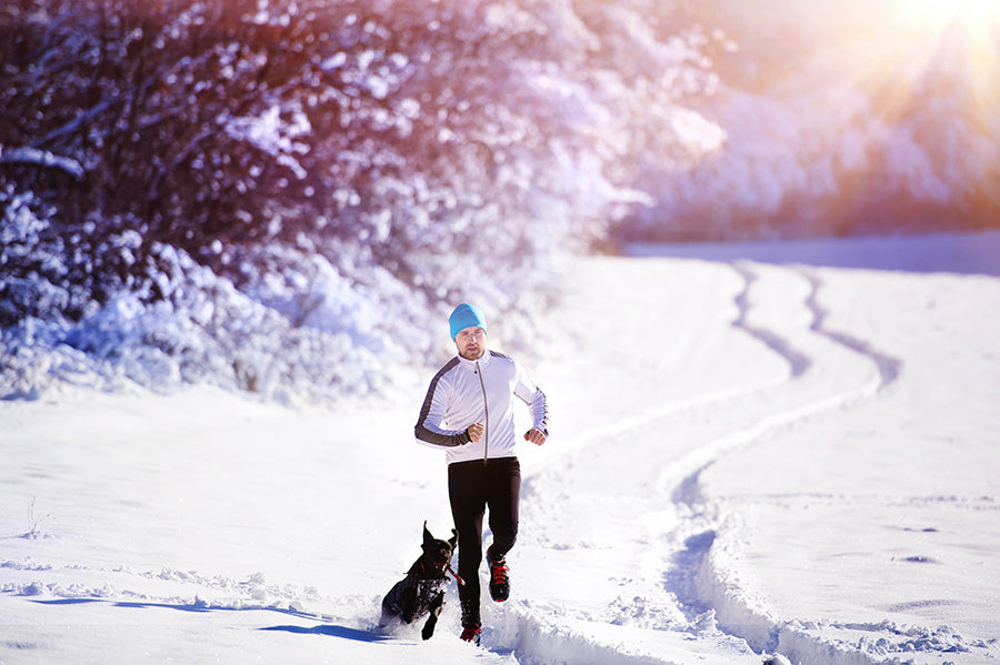 Man jogging with dog in winter