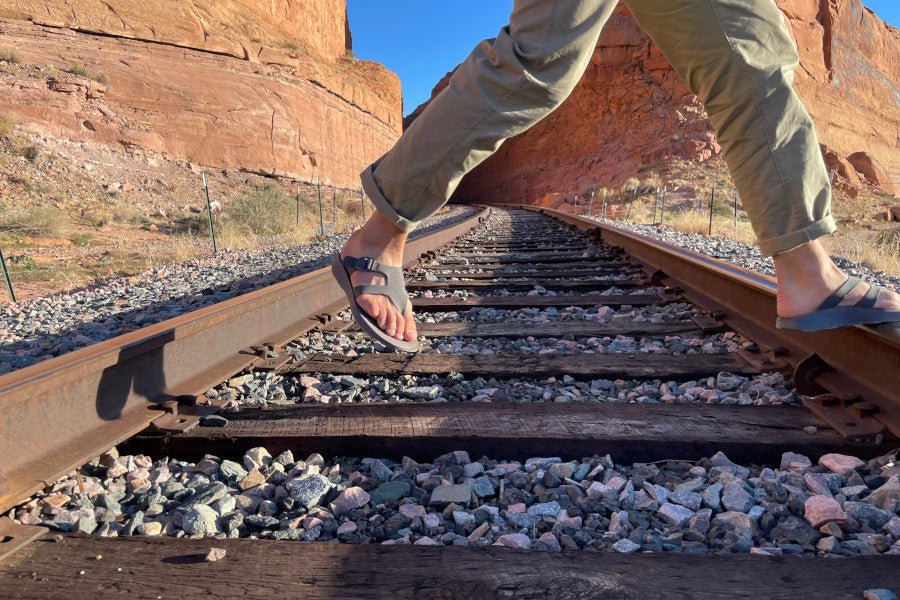 man crossing railroad in Tread Labs hiking sandals