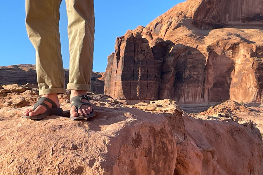 man standing on rock in sandals