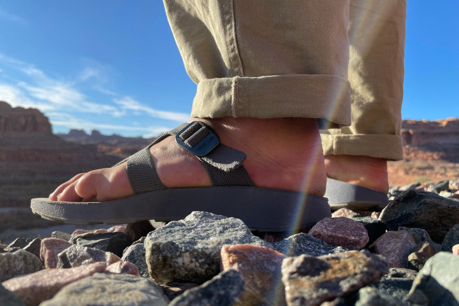 man standing on rocks in Tread Labs hiking sandals