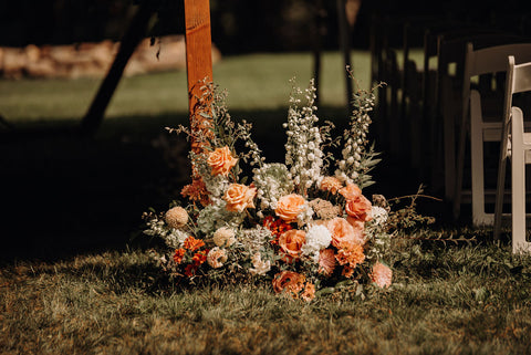 Image of grund ceremony flowers next to chuppah in various shades of pink flowers.