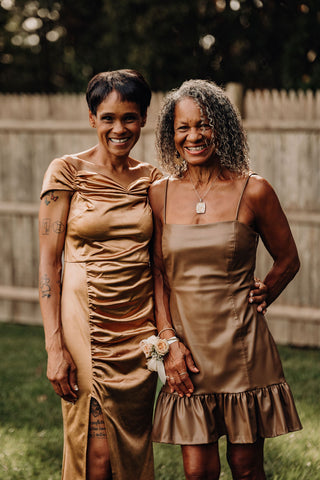 Image of bride's family members at wedding at Laurel Spring Farm. Both are weding metallic/champagne gold wedding dresses with flower corsage.