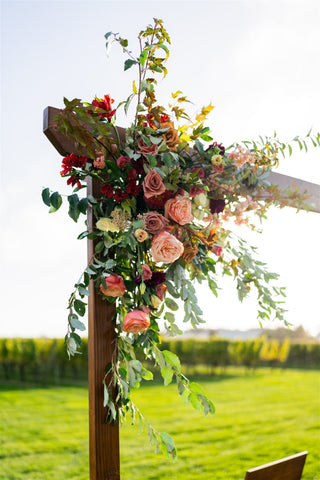 Wedding arbor rental with a muted fall color palette floral installation