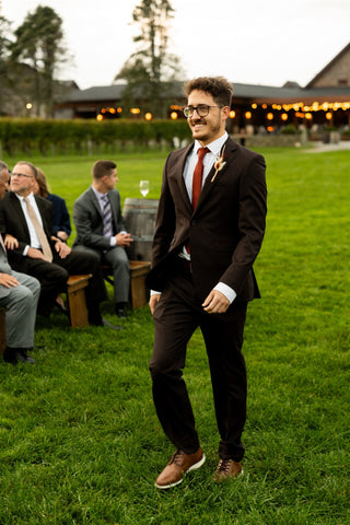 image of groomsman walking down the aisle. He has a a boutounniere.