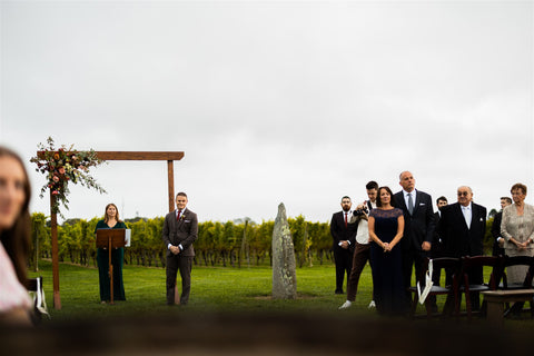 Image of wedding arbort at a wedding at Newport Vineyards. The wedding arbor is in the vineyard with the groom and officiant awaiting the bride to walk down the aisle.