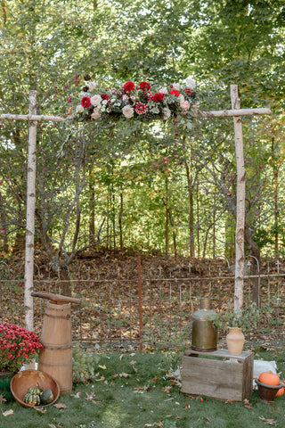 Wedding ceremony arch rustic elegance with deep red dahlias, roses and greenery at the Herb Lyceum.